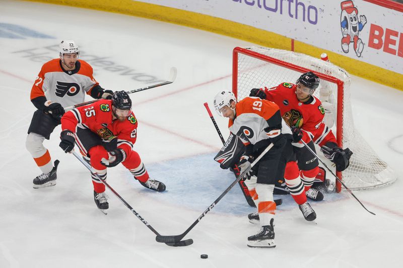 Feb 21, 2024; Chicago, Illinois, USA; Chicago Blackhawks defenseman Jarred Tinordi (25) battles for the puck with Philadelphia Flyers right wing Garnet Hathaway (19) during the first period at United Center. Mandatory Credit: Kamil Krzaczynski-USA TODAY Sports