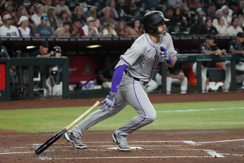 Aug 12, 2024; Phoenix, Arizona, USA; Colorado Rockies outfielder Jake Cave (11) hits a double against the Arizona Diamondbacks in the third inning at Chase Field. Mandatory Credit: Rick Scuteri-USA TODAY Sports