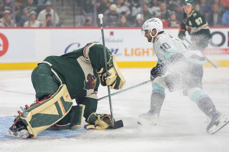 Oct 12, 2024; Saint Paul, Minnesota, USA; Seattle Kraken center Matty Beniers (10) sprays Minnesota Wild goaltender Marc-Andre Fleury (29) as he covers a shot in the first period at Xcel Energy Center. Mandatory Credit: Matt Blewett-Imagn Images