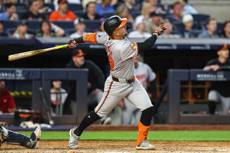 Jun 19, 2024; Bronx, New York, USA;  Baltimore Orioles third baseman Ramón Urías (29) hits a two-run home run in the fifth inning against the New York Yankees at Yankee Stadium. Mandatory Credit: Wendell Cruz-USA TODAY Sports