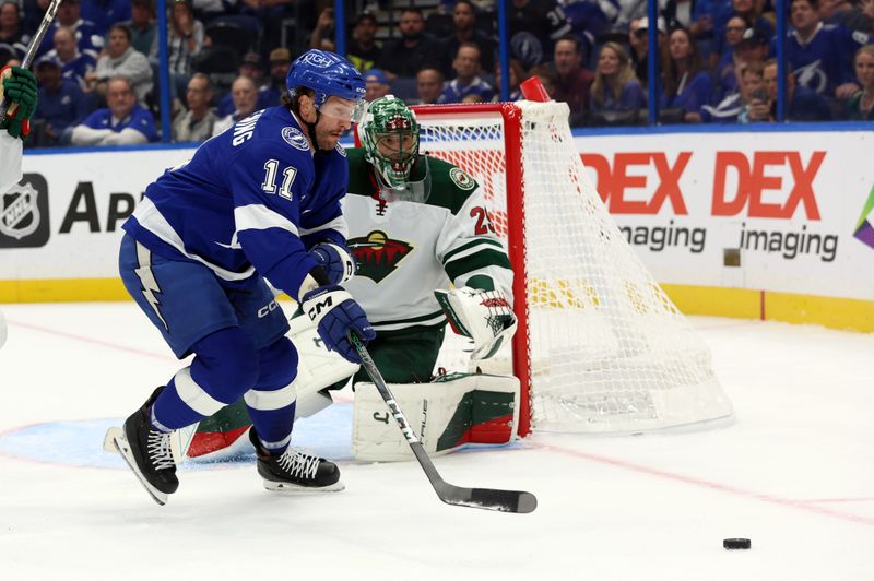 Oct 24, 2024; Tampa, Florida, USA; Tampa Bay Lightning center Luke Glendening (11) skates with the puck as Minnesota Wild goaltender Marc-Andre Fleury (29) defends during the first period at Amalie Arena. Mandatory Credit: Kim Klement Neitzel-Imagn Images