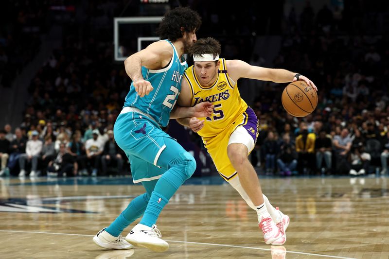 CHARLOTTE, NORTH CAROLINA - JANUARY 27: Austin Reaves #15 of the Los Angeles Lakers drives to the basket against Vasilije Micic #22 of the Charlotte Hornets during the first half of the game at Spectrum Center on January 27, 2025 in Charlotte, North Carolina. NOTE TO USER: User expressly acknowledges and agrees that, by downloading and or using this photograph, User is consenting to the terms and conditions of the Getty Images License Agreement. (Photo by Jared C. Tilton/Getty Images)