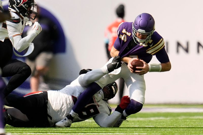 Minnesota Vikings quarterback Sam Darnold (14) is sacked by Houston Texans defensive tackle Tim Settle Jr. (98) during the first half of an NFL football game, Sunday, Sept. 22, 2024, in Minneapolis. (AP Photo/Abbie Parr)
