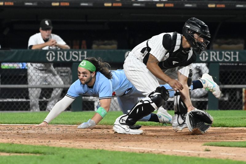 Jul 6, 2023; Chicago, Illinois, USA; Toronto Blue Jays shortstop Bo Bichette (11) scores against Chicago White Sox catcher Yasmani Grandal (24) during the seventh inning  at Guaranteed Rate Field. Mandatory Credit: Matt Marton-USA TODAY Sports