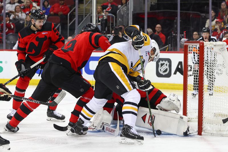 Mar 19, 2024; Newark, New Jersey, USA; New Jersey Devils goaltender Jake Allen (34) makes a save on Pittsburgh Penguins center Sidney Crosby (87) during the first period at Prudential Center. Mandatory Credit: Ed Mulholland-USA TODAY Sports