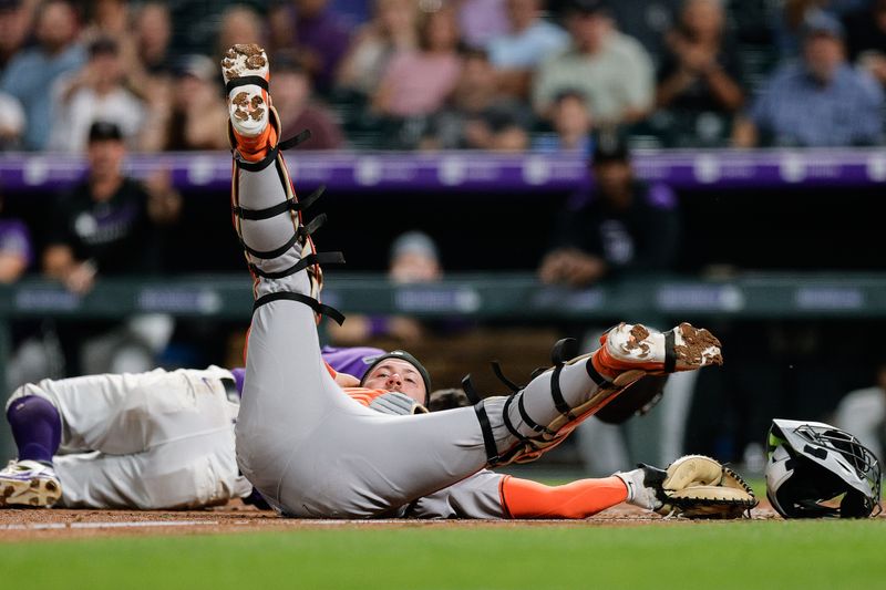 Sep 3, 2025; Denver, Colorado, USA; San Francisco Giants catcher Patrick Bailey (14) lies on the ground after a collision with Colorado Rockies right fielder Tyler Freeman (2) in the fifth inning at Coors Field. Mandatory Credit: Isaiah J. Downing-Imagn Images
