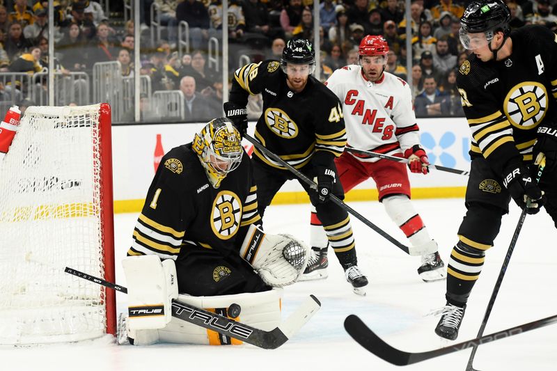 Apr 9, 2024; Boston, Massachusetts, USA; Boston Bruins goaltender Jeremy Swayman (1) makes a save in front of Boston Bruins defenseman while Boston Bruins defenseman Charlie McAvoy (73) looks on during the second period against the Carolina Hurricanes at TD Garden. Mandatory Credit: Bob DeChiara-USA TODAY Sports