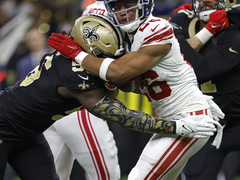 New York Giants running back Saquon Barkley (26) is tackled by New Orleans Saints defensive end Carl Granderson (96) during an NFL football game, Sunday, Dec. 17, 2023, in New Orleans. (AP Photo/Tyler Kaufman)