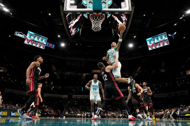 CHARLOTTE, NORTH CAROLINA - OCTOBER 08: Tre Mann #23 of the Charlotte Hornets goes to the basket against Kevin Love #42 of the Miami Heat during the first half of the preseason game at Spectrum Center on October 08, 2024 in Charlotte, North Carolina. NOTE TO USER: User expressly acknowledges and agrees that, by downloading and or using this photograph, User is consenting to the terms and conditions of the Getty Images License Agreement. (Photo by Grant Halverson/Getty Images)