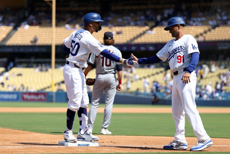 Sep 8, 2024; Los Angeles, California, USA;  Los Angeles Dodgers right fielder Mookie Betts (50) is greeted by third base coach Dino Ebel (91) after hitting a triple during the fourth inning against the Cleveland Guardians at Dodger Stadium. Mandatory Credit: Kiyoshi Mio-Imagn Images