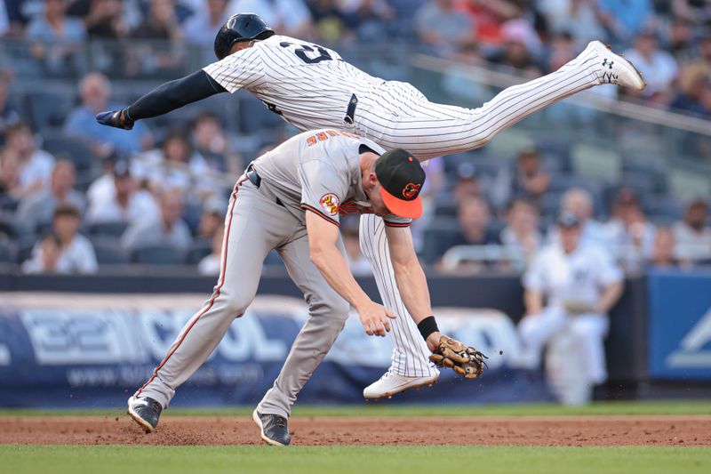 Jun 18, 2024; Bronx, New York, USA; New York Yankees right fielder Juan Soto (22) interferes with Baltimore Orioles third baseman Jordan Westburg (11) during the first inning at Yankee Stadium. Mandatory Credit: Vincent Carchietta-USA TODAY Sports