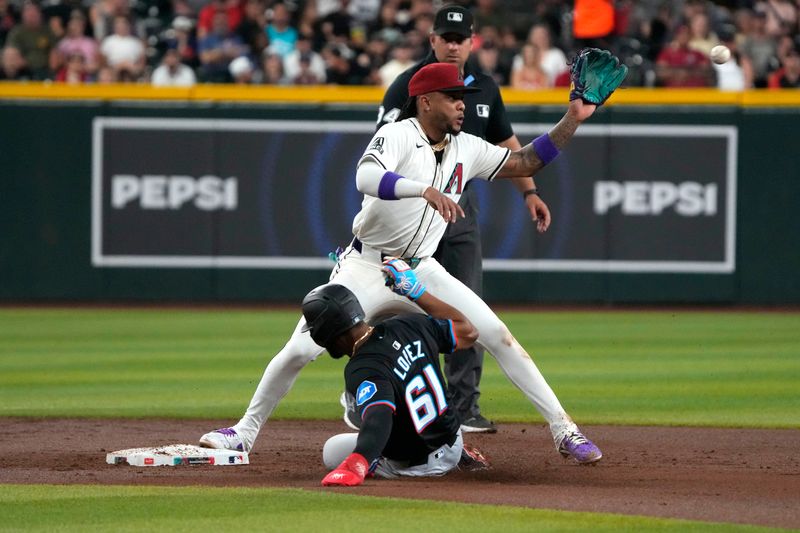 May 24, 2024; Phoenix, Arizona, USA; Arizona Diamondbacks second base Ketel Marte (4) gets the force out on Miami Marlins third base Otto Lopez (61) in the second inning at Chase Field. Mandatory Credit: Rick Scuteri-USA TODAY Sports