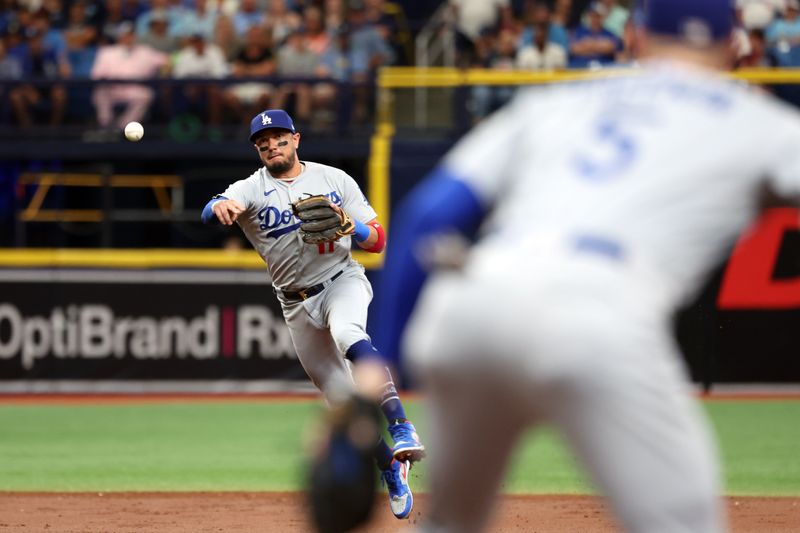 May 27, 2023; St. Petersburg, Florida, USA; Los Angeles Dodgers shortstop Miguel Rojas (11) throws the ball to first baseman Freddie Freeman (5) for an out during the third inning against the Tampa Bay Rays  at Tropicana Field. Mandatory Credit: Kim Klement-USA TODAY Sports