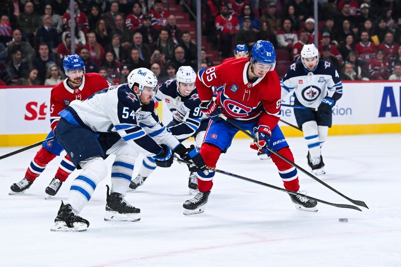 Dec 3, 2025; Montreal, Quebec, CAN; Winnipeg Jets defenseman Dylan Samberg (54) defends the puck against Montreal Canadiens left wing Alexandre Texier (85) during the first period at Bell Centre. Mandatory Credit: David Kirouac-Imagn Images