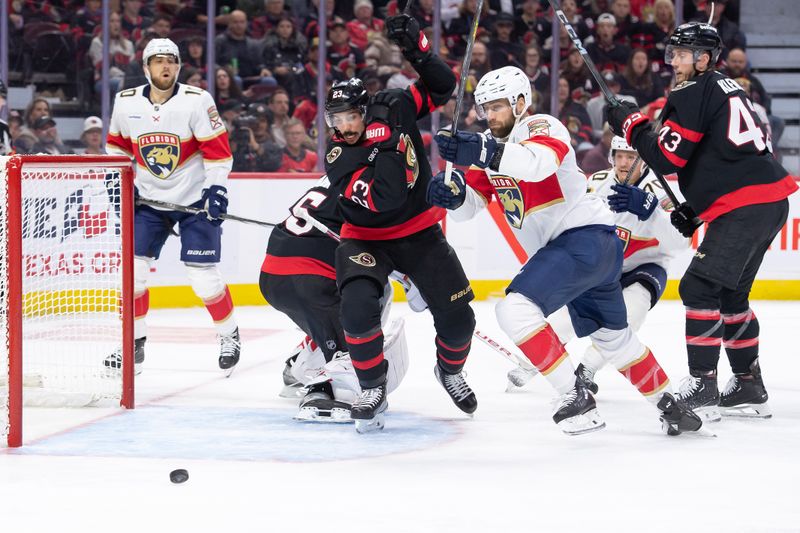 Oct 10, 2024; Ottawa, Ontario, CAN; Ottawa Senators defenseman Travis Hamonic (23) and Florida Panthers left wing Jonah Gadjovich (12) chase the puck in the second period at the Canadian Tire Centre. Mandatory Credit: Marc DesRosiers-Imagn Images