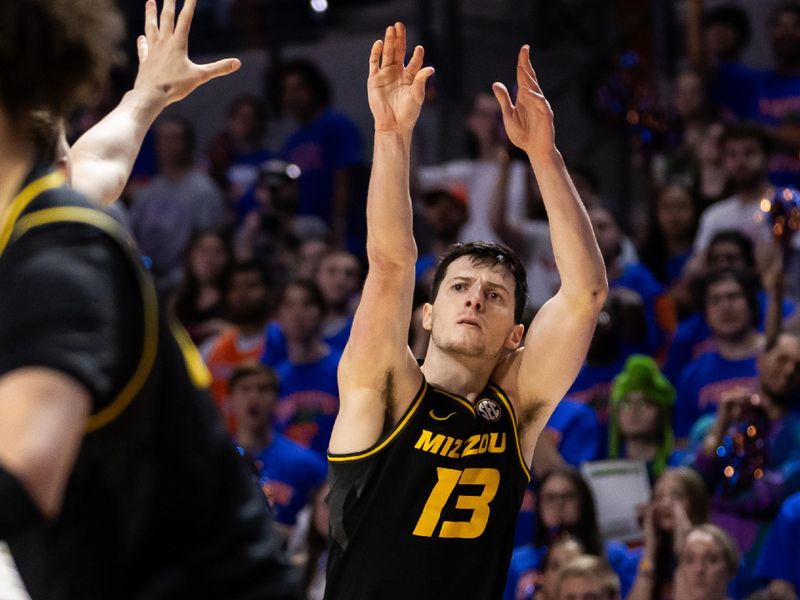 Feb 28, 2024; Gainesville, Florida, USA; Missouri Tigers forward Jesus Carralero Martin (13) attempts a three-point shot over Florida Gators center Micah Handlogten (3) during the first half at Exactech Arena at the Stephen C. O'Connell Center. Mandatory Credit: Matt Pendleton-USA TODAY Sports