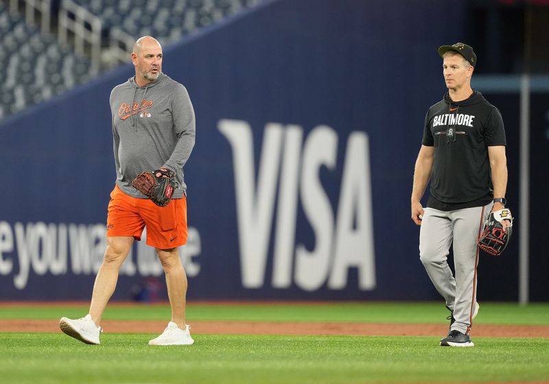 Aug 6, 2024; Toronto, Ontario, CAN; Baltimore Orioles manager Brandon Hyde (18) walks back towards the dugout with third base coach Tony Mansolino (36) during batting practice before a game against the Toronto Blue Jays at Rogers Centre. Mandatory Credit: Nick Turchiaro-USA TODAY Sports