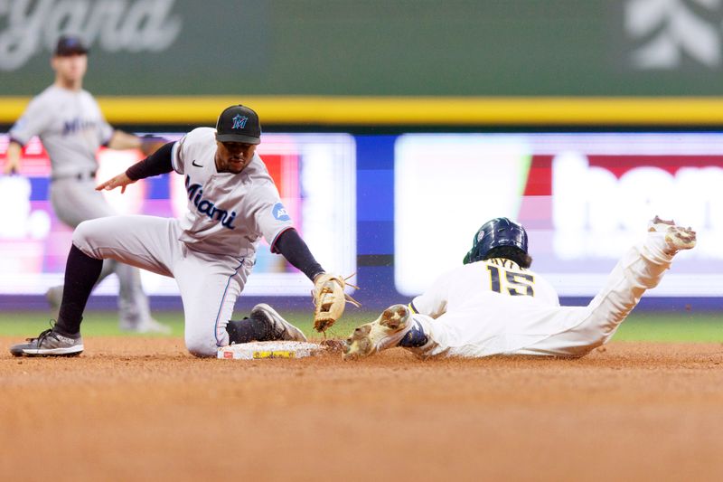 Sep 11, 2023; Milwaukee, Wisconsin, USA;  Milwaukee Brewers left fielder Tyrone Taylor (15) dives into second base before Miami Marlins second baseman Xavier Edwards (63) can apply the tag during the fifth inning at American Family Field. Mandatory Credit: Jeff Hanisch-USA TODAY Sports