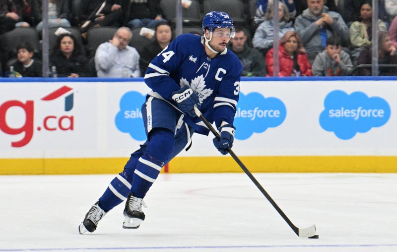 Oct 31, 2024; Toronto, Ontario, CAN;  Toronto Maple Leafs forward Auston Matthews (34) skates with the puck against the Seattle Kraken in the first period at Scotiabank Arena. Mandatory Credit: Dan Hamilton-Imagn Images