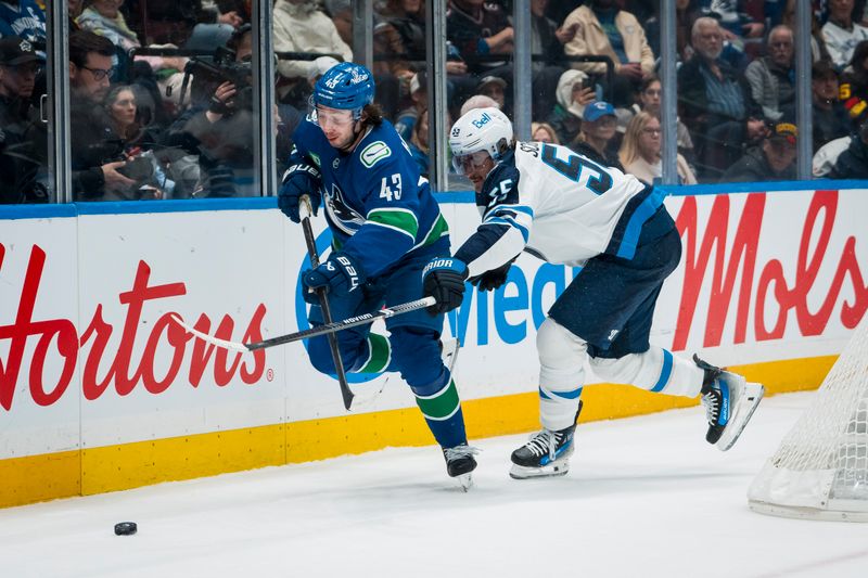 Nov 11, 2025; Vancouver, British Columbia, CAN; Winnipeg Jets forward Mark Scheifele (55) stick checks Vancouver Canucks defenseman Quinn Hughes (43) in the first period at Rogers Arena. Mandatory Credit: Bob Frid-Imagn Images