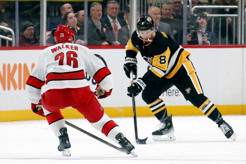 Oct 18, 2024; Pittsburgh, Pennsylvania, USA;  Pittsburgh Penguins left wing Michael Bunting (8) skates with the puck against Carolina Hurricanes defenseman Sean Walker (26) during the first period at PPG Paints Arena. Mandatory Credit: Charles LeClaire-Imagn Images