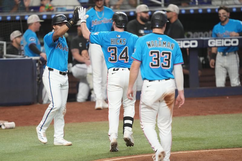 May 18, 2025; Miami, Florida, USA;  Miami Marlins catcher Liam Hicks (34) celebrates a two-run home run with shortstop Javier Sanoja, left, in the sixth inning against the Tampa Bay Rays at loanDepot Park. Mandatory Credit: Jim Rassol-Imagn Images