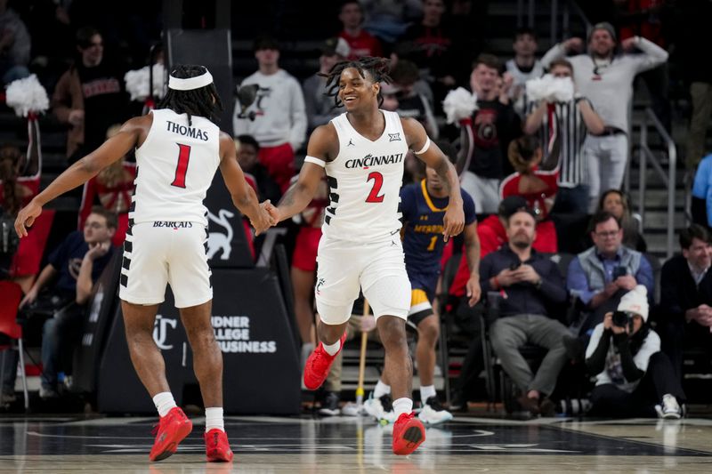 Dec 19, 2023; Cincinnati, Ohio, USA; Cincinnati Bearcats guard Jizzle James (2) high-fives guard Day Day Thomas (1) after a play against the Merrimack Warriors in the second half at Fifth Third Arena. Mandatory Credit: Aaron Doster-USA TODAY Sports