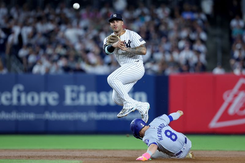 Jun 9, 2024; Bronx, New York, USA; New York Yankees second baseman Gleyber Torres (25) steps on second base to force out Los Angeles Dodgers third baseman Enrique Hernandez (8) and throws to first to complete a double play on a ball hit by Dodgers shortstop Mookie Betts (not pictured) during the seventh inning at Yankee Stadium. Mandatory Credit: Brad Penner-USA TODAY Sports