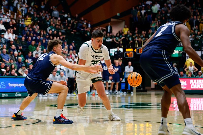Jan 23, 2026; Fort Collins, Colorado, USA; Utah State Aggies guard Mason Falslev (12) knocks the ball away from Colorado State Rams forward Kyle Jorgensen (35) as guard MJ Collins Jr. (2) looks on in the second half at Moby Arena. Mandatory Credit: Isaiah J. Downing-Imagn Images