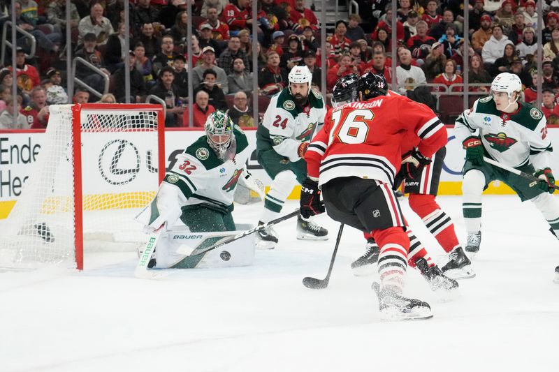 Nov 26, 2025; Chicago, Illinois, USA; Minnesota Wild goaltender Filip Gustavsson (32) makes a save on Chicago Blackhawks center Jason Dickinson (16) during the second period at United Center. Mandatory Credit: David Banks-Imagn Images