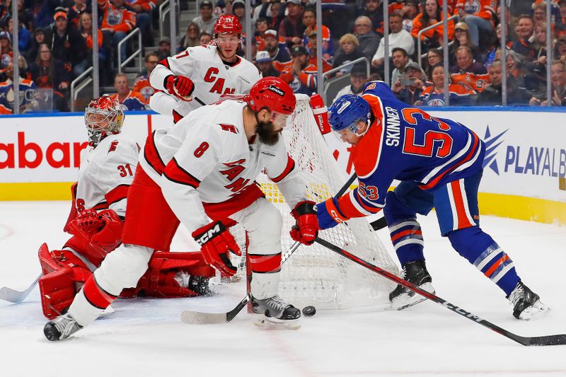 Oct 22, 2024; Edmonton, Alberta, CAN; Edmonton Oilers forward Jeff Skinner (53) tries to jam a loose puck past Carolina Hurricanes defensemen Brent Burns (8) and goaltender Frederik Andersen (31) during the third period at Rogers Place. Mandatory Credit: Perry Nelson-Imagn Images