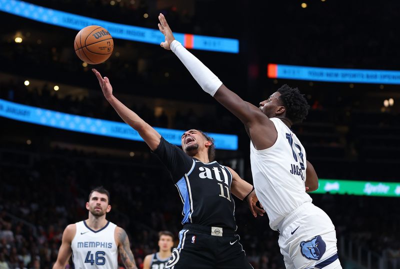 ATLANTA, GEORGIA - DECEMBER 23:  Trae Young #11 of the Atlanta Hawks attacks the basket as he draws a foul from Jaren Jackson Jr. #13 of the Memphis Grizzlies during the second quarter at State Farm Arena on December 23, 2023 in Atlanta, Georgia.  NOTE TO USER: User expressly acknowledges and agrees that, by downloading and/or using this photograph, user is consenting to the terms and conditions of the Getty Images License Agreement. (Photo by Kevin C. Cox/Getty Images)