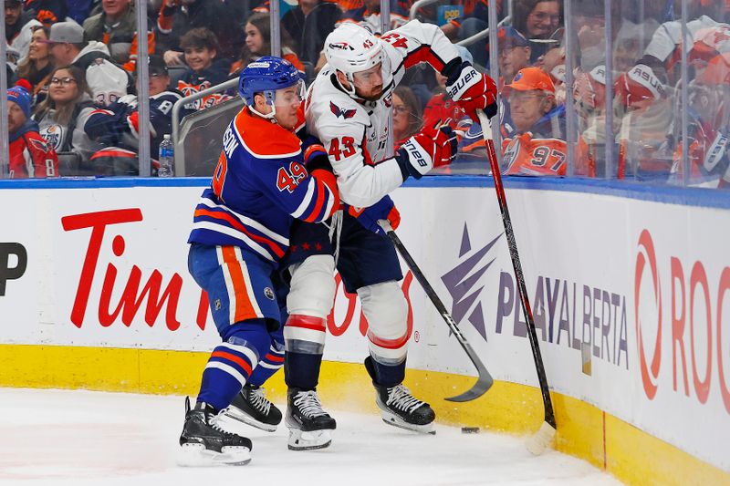 Jan 21, 2025; Edmonton, Alberta, CAN; Edmonton Oilers defensemen Ty Emberson (49) and Washington Capitals forward Tom Wilson (43) battle for a loose puck during the second period at Rogers Place. Mandatory Credit: Perry Nelson-Imagn Images
