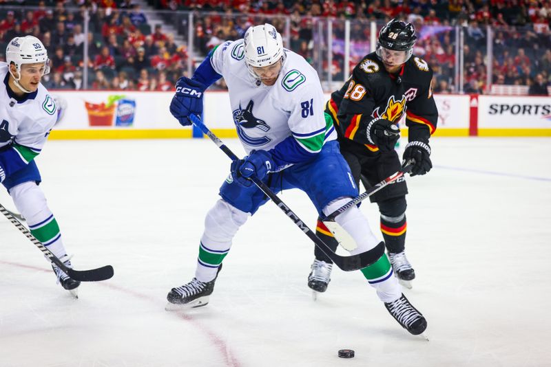 Dec 2, 2023; Calgary, Alberta, CAN; Vancouver Canucks center Dakota Joshua (81) and Calgary Flames center Elias Lindholm (28) battle for the puck during the third period at Scotiabank Saddledome. Mandatory Credit: Sergei Belski-USA TODAY Sports