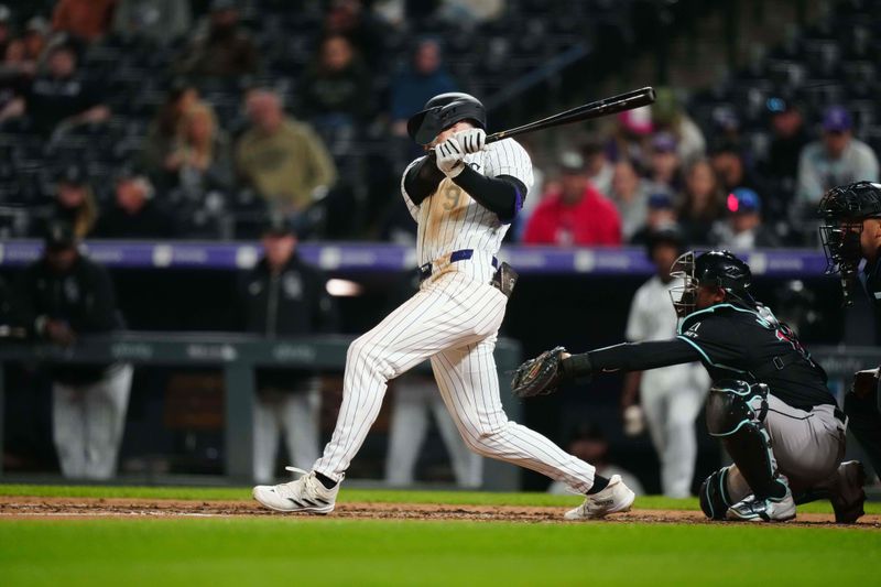 Apr 9, 2024; Denver, Colorado, USA; Colorado Rockies center fielder Brenton Doyle (9) singles the ball in the seventh inning against the Arizona Diamondbacks at Coors Field. Mandatory Credit: Ron Chenoy-USA TODAY Sports