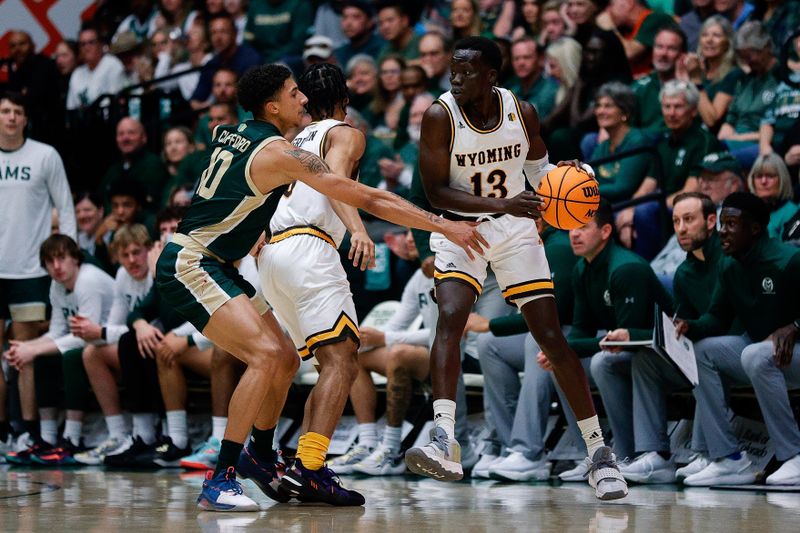 Mar 2, 2024; Fort Collins, Colorado, USA; Wyoming Cowboys guard Akuel Kot (13) controls the ball as Colorado State Rams guard Nique Clifford (10) guards in the first half at Moby Arena. Mandatory Credit: Isaiah J. Downing-USA TODAY Sports