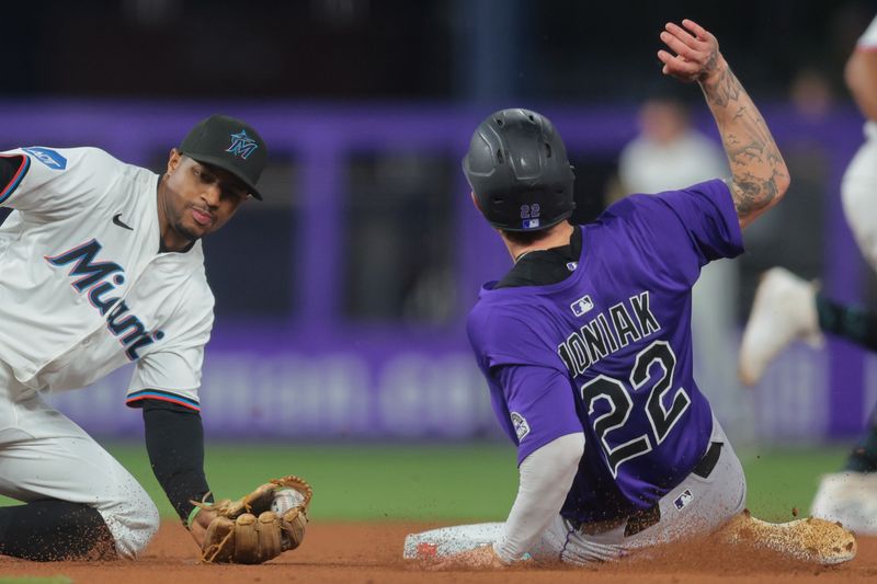 Jun 3, 2025; Miami, Florida, USA; Colorado Rockies right fielder Mickey Moniak (22) steals second base against Miami Marlins shortstop Xavier Edwards (9) during the fifth inning at loanDepot Park. Mandatory Credit: Sam Navarro-Imagn Images