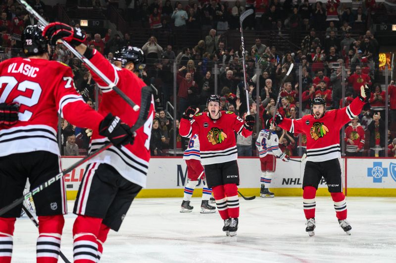 Feb 9, 2024; Chicago, Illinois, USA; Chicago Blackhawks right wing MacKenzie Entwistle (58) and left wing Boris Katchouk (14) celebrate a defenseman Alex Vlasic (72) goal against the New York Rangers during the first period at the United Center. Mandatory Credit: Daniel Bartel-USA TODAY Sports