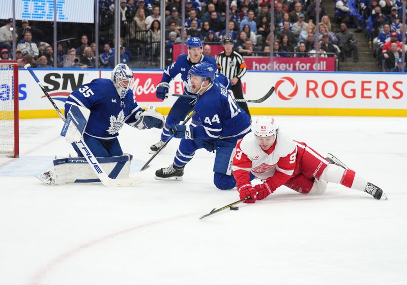 Apr 13, 2024; Toronto, Ontario, CAN; Toronto Maple Leafs defenseman Morgan Rielly (44) battles for the puck with Detroit Red Wings right wing Alex DeBrincat (93) during the second period at Scotiabank Arena. Mandatory Credit: Nick Turchiaro-USA TODAY Sports