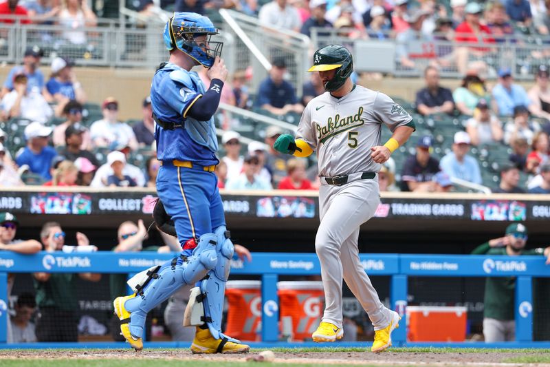 Jun 16, 2024; Minneapolis, Minnesota, USA; Oakland Athletics third baseman J.D. Davis (5) scores on a single hit by catcher Kyle McCann (52) during the ninth inning of game one of a double header against the Minnesota Twins at Target Field. Mandatory Credit: Matt Krohn-USA TODAY Sports