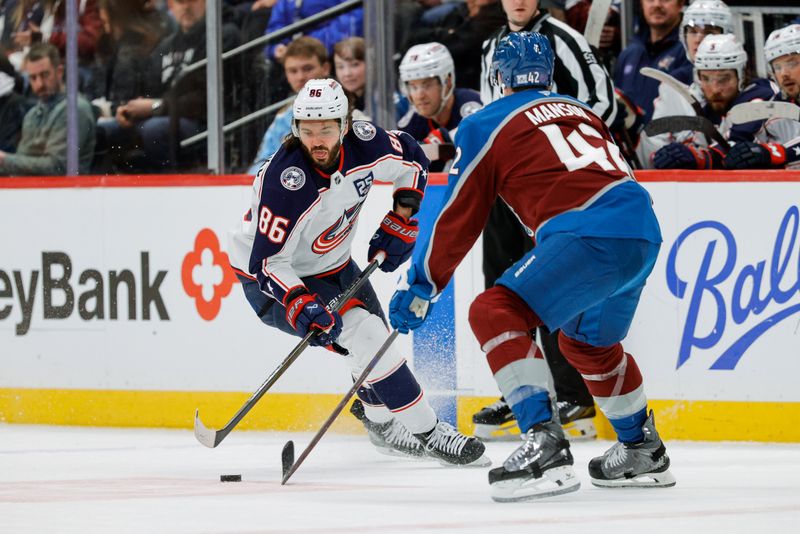 Jan 10, 2026; Denver, Colorado, USA; Columbus Blue Jackets right wing Kirill Marchenko (86) controls the puck against Colorado Avalanche defenseman Josh Manson (42) in the first period at Ball Arena. Mandatory Credit: Isaiah J. Downing-Imagn Images