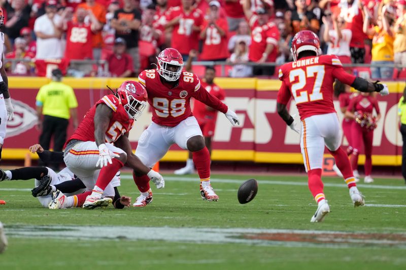 Kansas City Chiefs defenders Mike Danna, left, Tershawn Wharton (98) and Chamarri Conner (27) chase a fumble by Cincinnati Bengals quarterback Joe Burrow before it was recovered and run back for a touchdown by Conner during the second half of an NFL football game Sunday, Sept. 15, 2024, in Kansas City, Mo. (AP Photo/Ed Zurga)