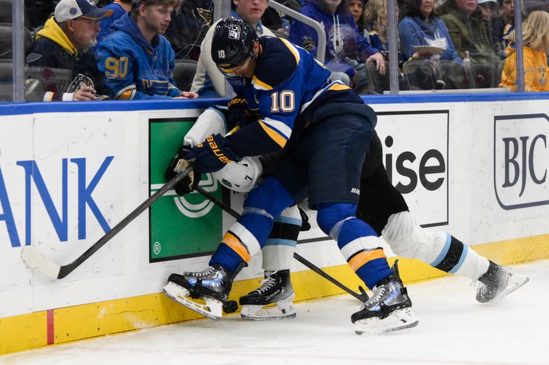 Nov 7, 2024; St. Louis, Missouri, USA; St. Louis Blues center Brayden Schenn (10) checks Utah Hockey Club defenseman Michael Kesselring (7) during the second  period at Enterprise Center. Mandatory Credit: Jeff Le-Imagn Images