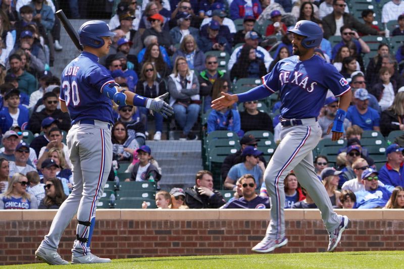 Apr 9, 2023; Chicago, Illinois, USA; Texas Rangers second baseman Marcus Semien (2) is greeted by first baseman Nathaniel Lowe (30) after scoring against the Chicago Cubs during the sixth inning at Wrigley Field. Mandatory Credit: David Banks-USA TODAY Sports