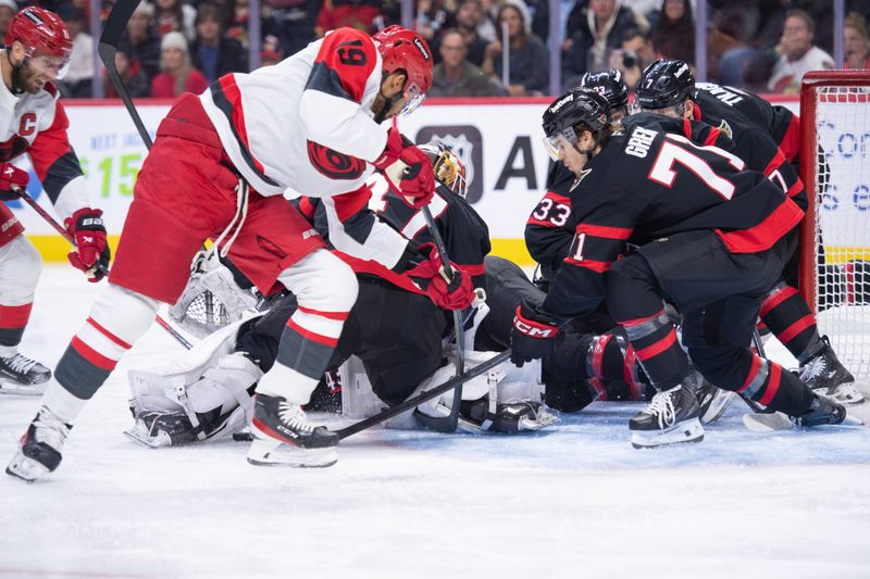 Jan 24, 2026; Ottawa, Ontario, CAN; Ottawa Senators center Ridly Greig (71), defenseman Nikolas Matinpalo (33) and left wing Brady Tkachuk (7) come to support goalie James Reimer (47) as Carolina Hurricanes defenseman K'Andre Miller (19) tries to free the puck in the second period at the Canadian Tire Centre. Mandatory Credit: Marc DesRosiers-IMAGN Images