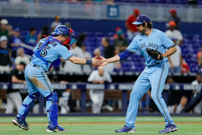 Jun 21, 2023; Miami, Florida, USA; Toronto Blue Jays catcher Tyler Heineman (55) and relief pitcher Jordan Romano (68) celebrate after winning the game against the Miami Marlins at loanDepot Park. Mandatory Credit: Sam Navarro-USA TODAY Sports