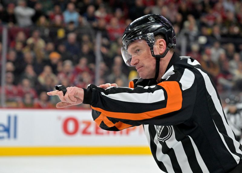 Mar 18, 2025; Montreal, Quebec, CAN; referee Kelly Sutherland (11) calls a penalty on Montreal Canadiens forward Juraj Slafkovsky (20) (not pictured) during the second period of the game against the Ottawa Senators at the Bell Centre. Mandatory Credit: Eric Bolte-Imagn Images
