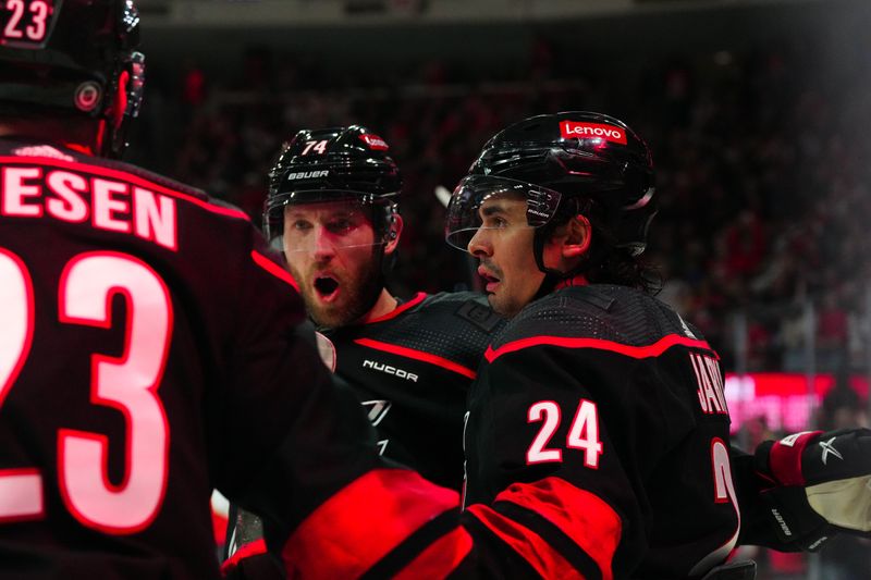 Mar 14, 2024; Raleigh, North Carolina, USA; Carolina Hurricanes center Seth Jarvis (24) is congratulated after his goal by defenseman Jaccob Slavin (74) during the first period at PNC Arena. Mandatory Credit: James Guillory-USA TODAY Sports