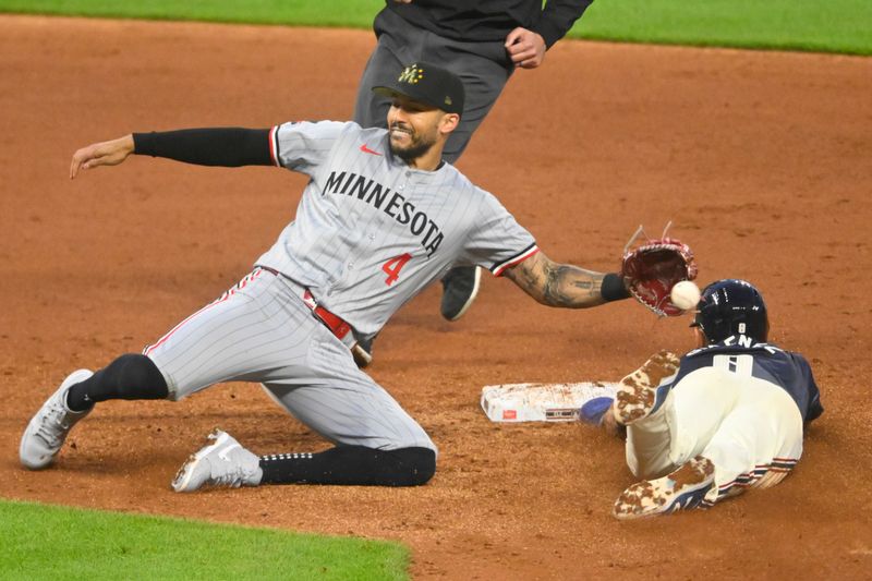 May 17, 2024; Cleveland, Ohio, USA; Cleveland Guardians second baseman Andres Gimenez (0) steals second base beside Minnesota Twins shortstop Carlos Correa (4) in the sixth inning at Progressive Field. Mandatory Credit: David Richard-USA TODAY Sports