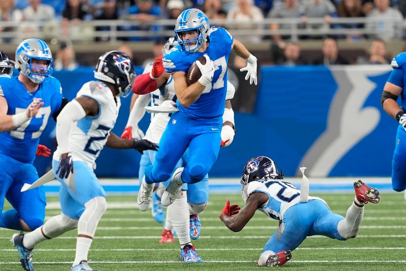 Detroit Lions tight end Sam LaPorta, center, runs the ball after a catch past Tennessee Titans cornerback Jarvis Brownlee Jr., right, during the second half of an NFL football game Sunday, Oct. 27, 2024, in Detroit. (AP Photo/Carlos Osorio)